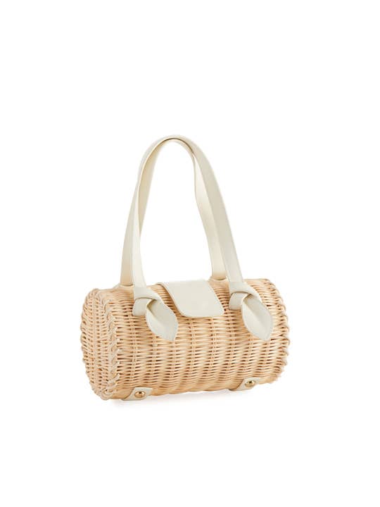 A natural rattan handbag with ivory handle and accents and handles against a white background