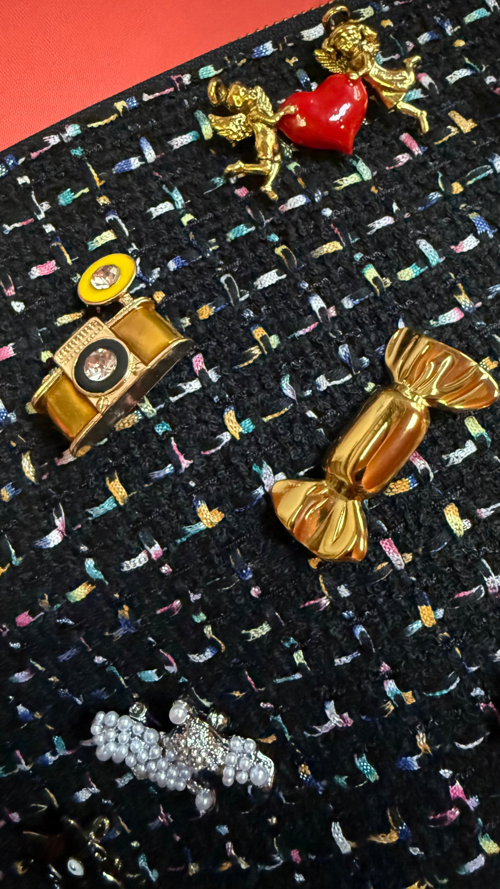 Collection of decorative brooches on a black textured background with colorful designs.