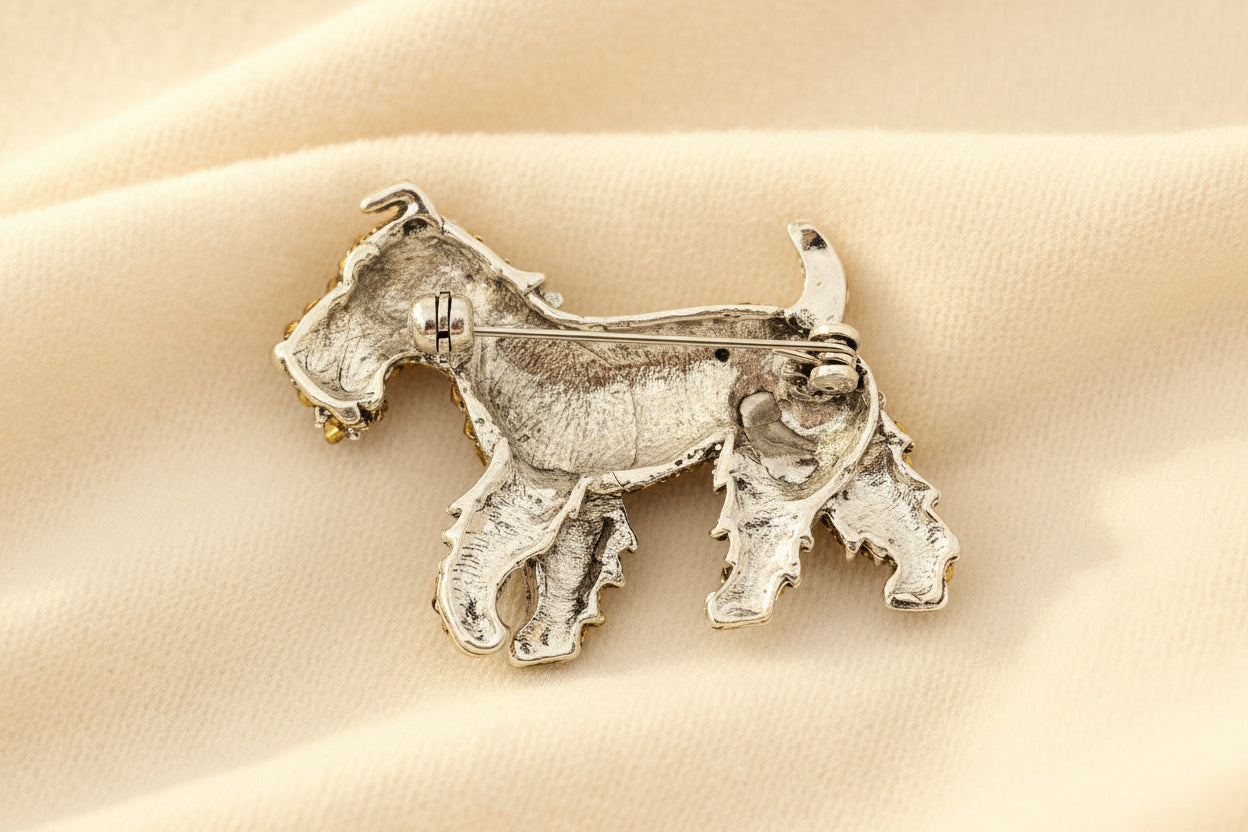 back view of crystal encrusted schnauzer dog brooch to show the pin closure against a grey background