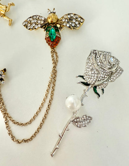 up close view of 2 decorative brooches against a white background