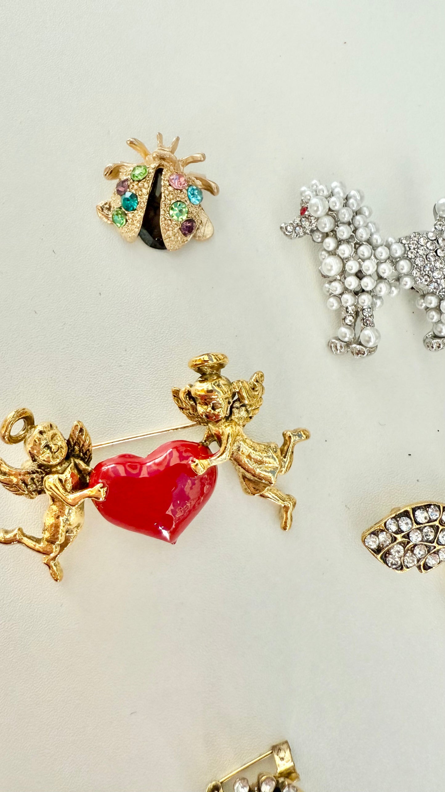up close view of 3 decorative brooches against a white background