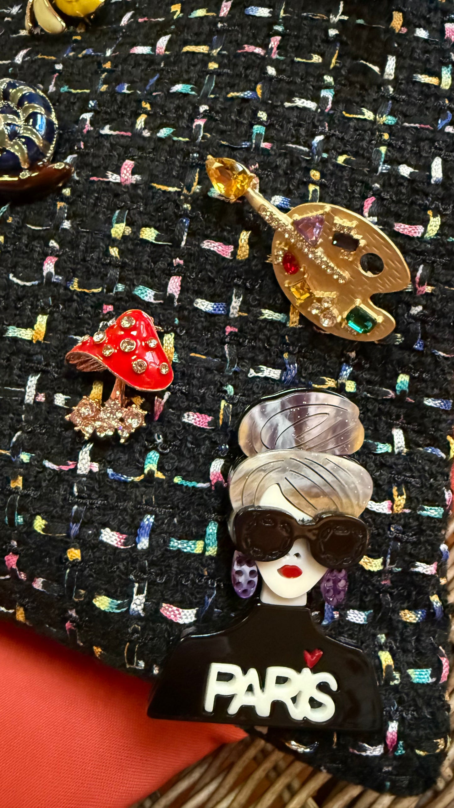 Collection of colorful brooches on a textured black surface