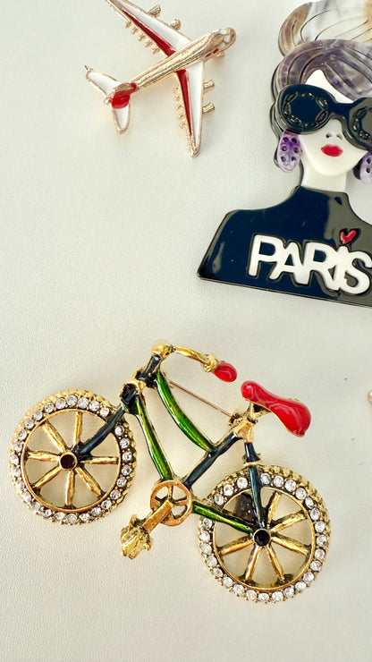 Bicycle-shaped brooch with rhinestones on a white background