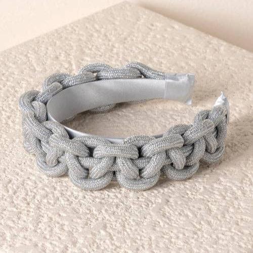 silver braided headband against an ivory textured background