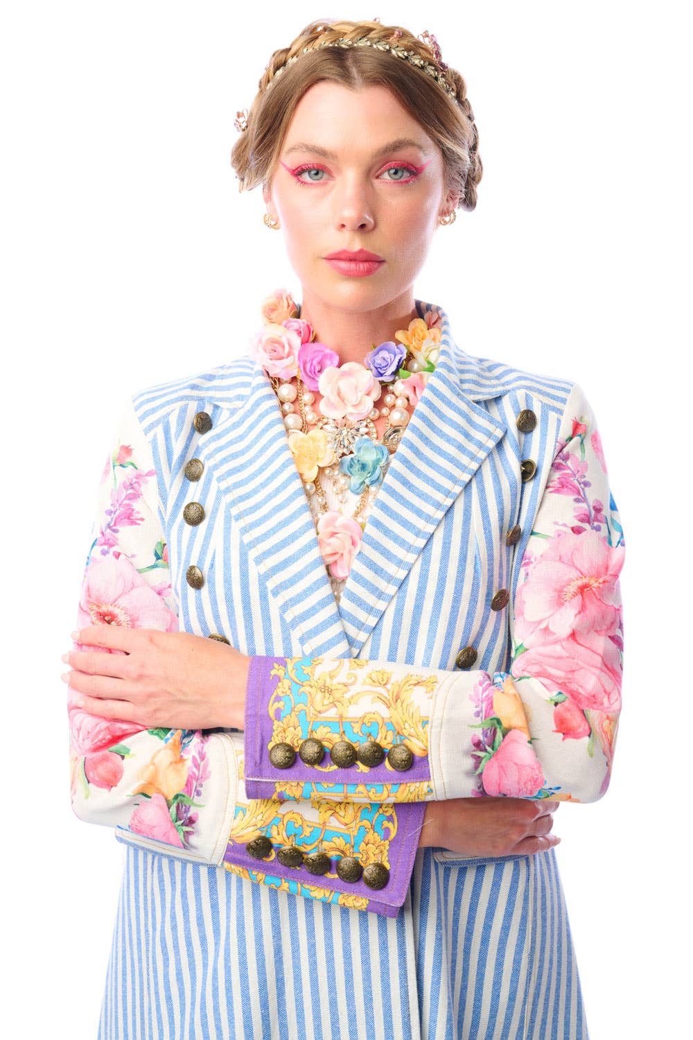 Woman wearing a blue and white striped coat with colorful floral print sleeves and antique gold button closure n a white background