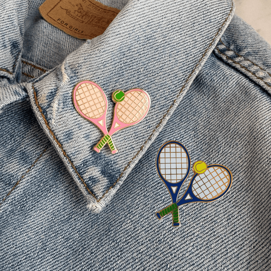 Two colorful tennis racket pins on a denim jacket.