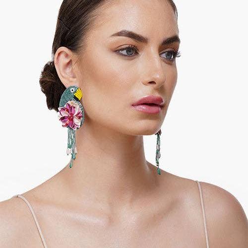 woman wearing tucan and floral beaded dangle earrings