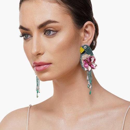 woman wearing tucan and floral beaded dangle earrings