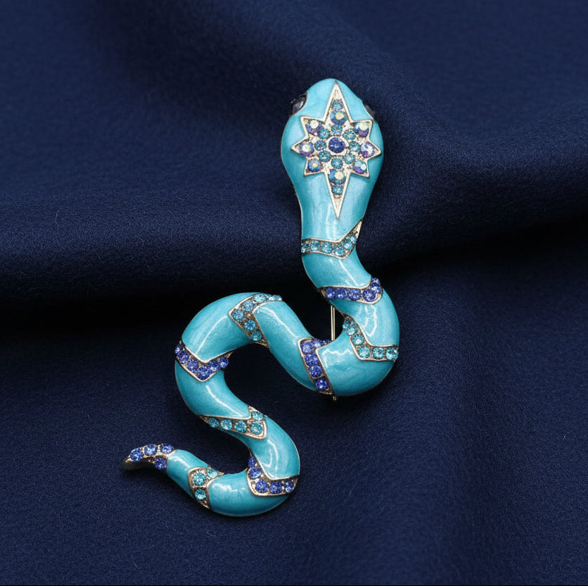 Decorative blue snake-shaped brooch with star design on a light gray background