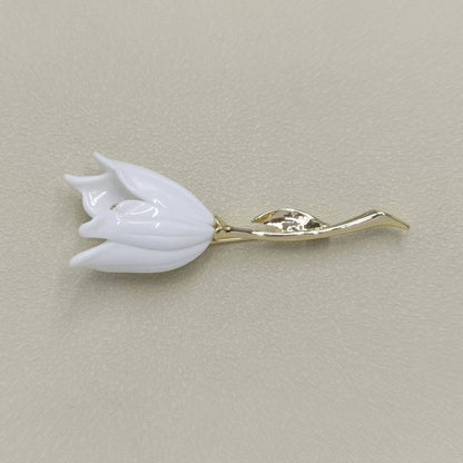 White tulip-shaped brooch on a beige background