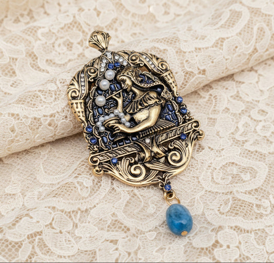 Decorative pendant with intricate design and blue gemstone on an ivory lace fabric