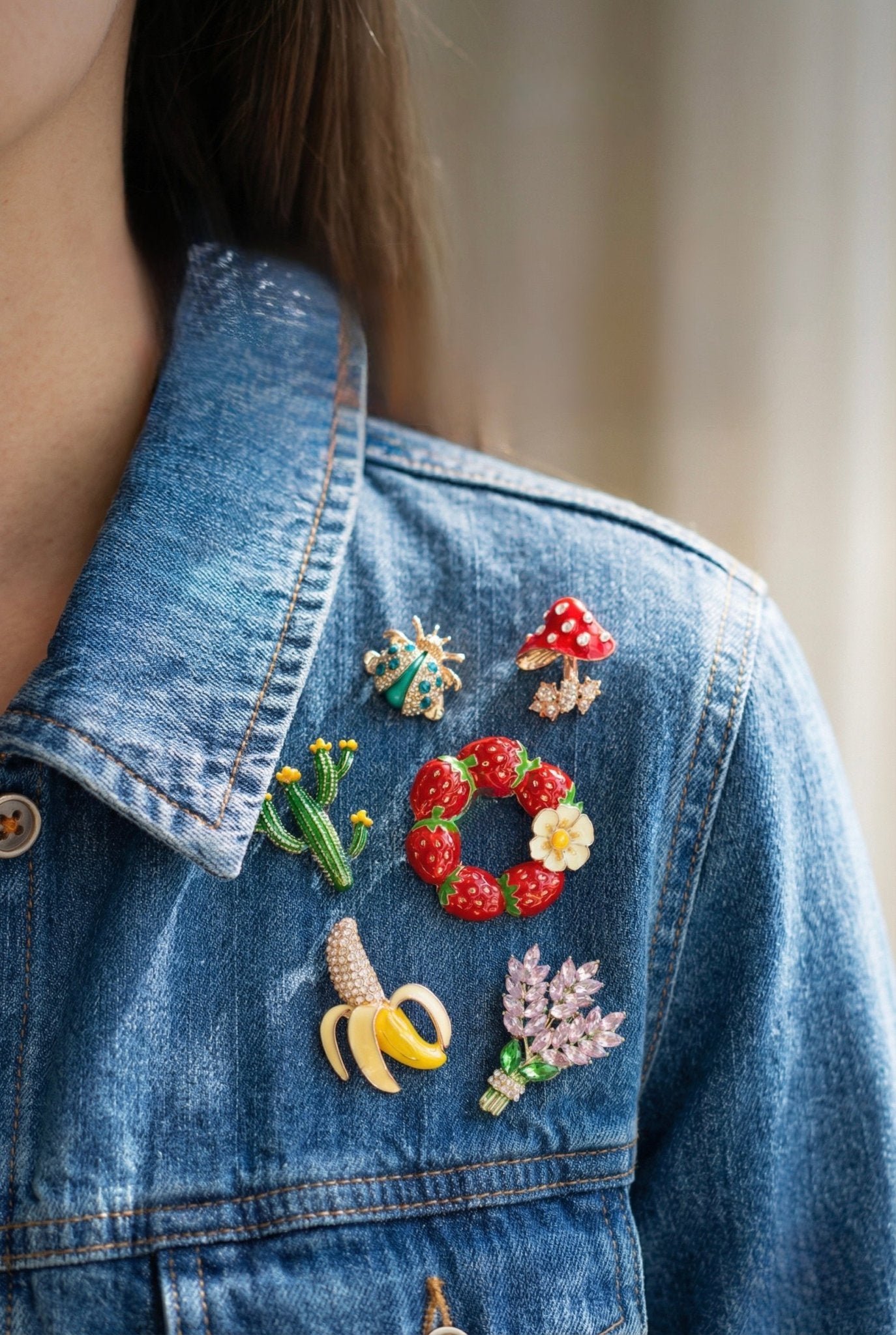 Six-piece whimsical garden brooch set clustered on denim jacket