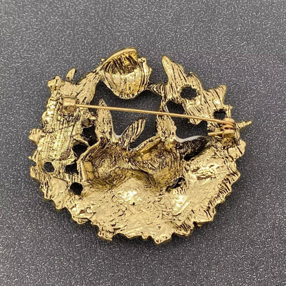 back view of bunny brooch in gold color on a gray background