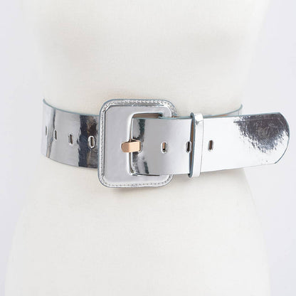 A silver colored wide mirror belt with a square buckle, displayed on a mannequin against a white background